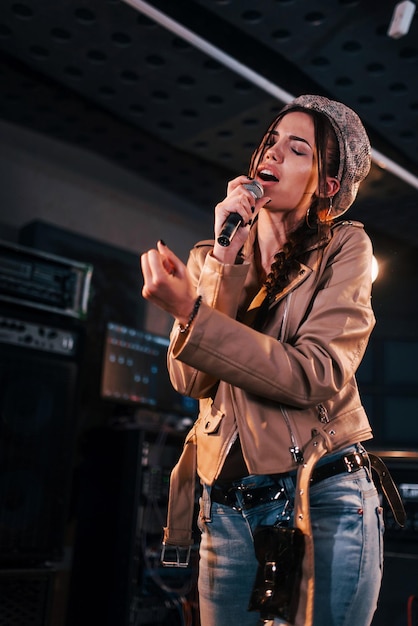 Belle jeune chanteuse en répétition dans un studio d'enregistrement