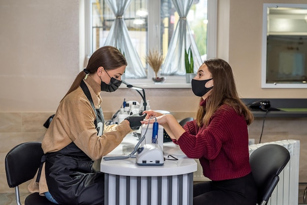 Belle jeune cliente est venue au salon de beauté pour un nouveau concept de salon de beauté manucure