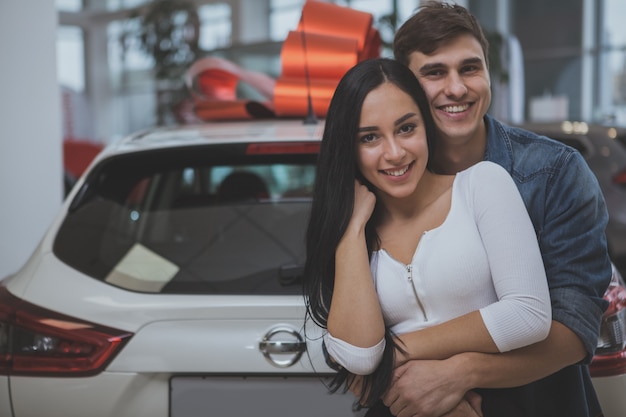 Belle jeune couple marié, acheter une nouvelle voiture ensemble