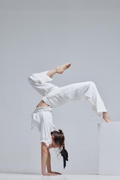 Belle jeune danseuse moderne ou danseuse de fitness sur fond blanc isolé