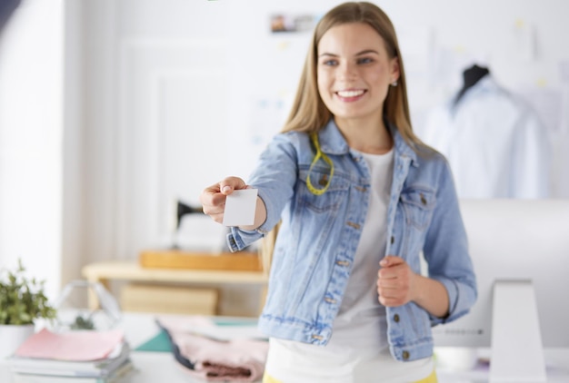 Belle jeune designer avec carte de visite au bureau