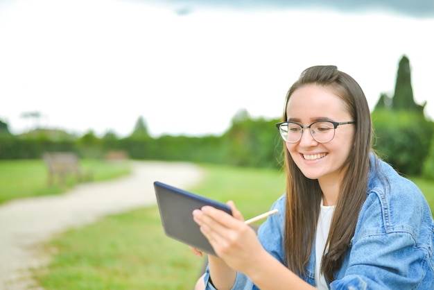 belle jeune étudiante apprend en plein air