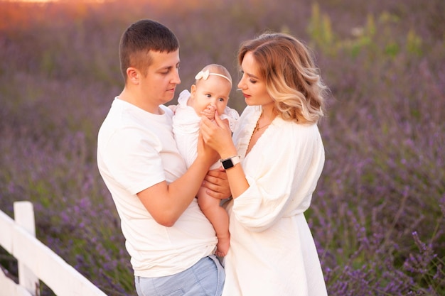 Belle jeune famille sur le champ de lavande fleur pourpre. Vacances en famille