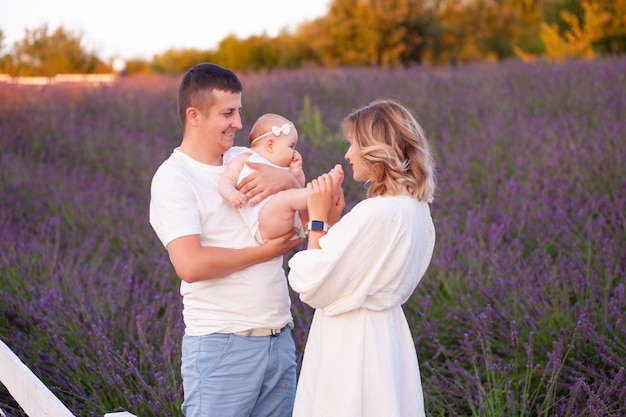 Belle jeune famille sur le champ de lavande fleur pourpre. Vacances en famille