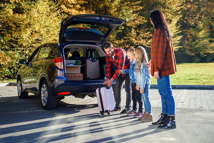Photo belle jeune famille chargeant la voiture