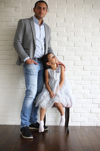 Belle jeune famille avec filles lors d'une séance photo dans un studio blanc