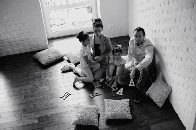 Belle jeune famille avec filles lors d'une séance photo dans un studio blanc