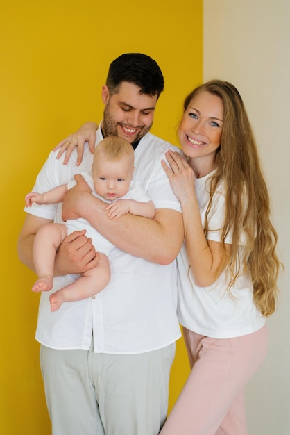 Belle jeune famille heureuse avec un petit garçon dans les bras