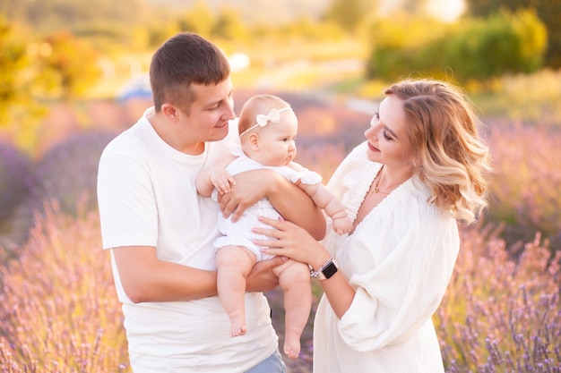 Belle jeune famille, père et mère avec bébé sur champ de lavande