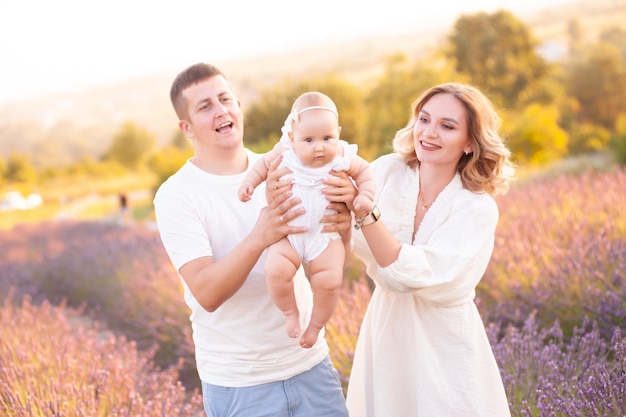 Belle jeune famille, père et mère avec bébé sur champ de lavande