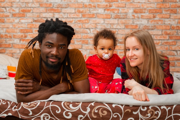 Photo belle jeune famille avec petite fille à la maison