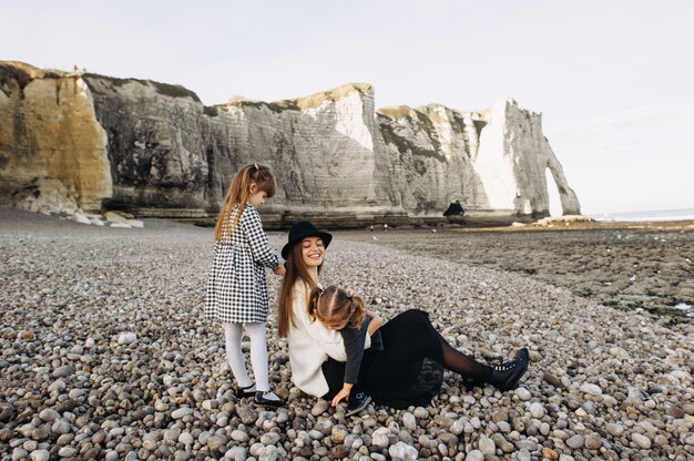 Une belle jeune famille sur le rivage sablonneux de l'océan se détendre et s'amuser