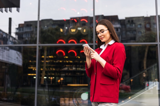 Belle jeune femme d'affaires à l'aide d'un smartphone