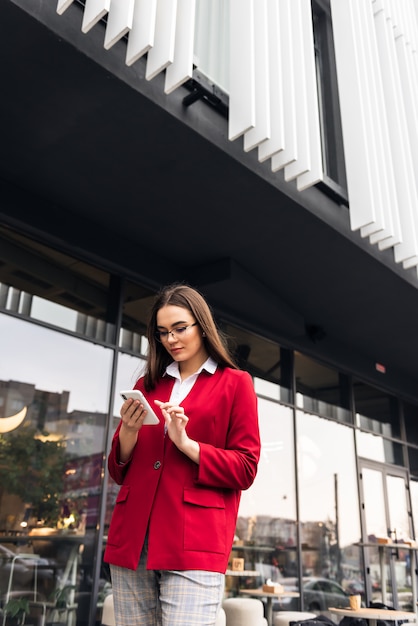 Belle jeune femme d'affaires à l'aide d'un smartphone