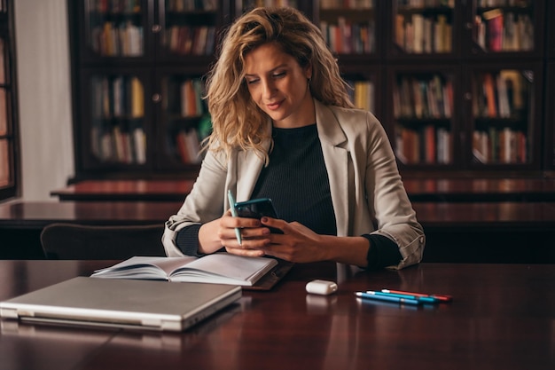 Belle jeune femme d'affaires à l'aide d'un smartphone