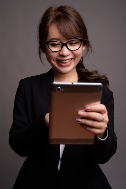 Belle jeune femme d'affaires asiatique à l'aide de tablette numérique