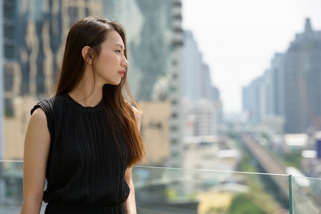 Belle jeune femme d'affaires asiatique contre vue sur la ville