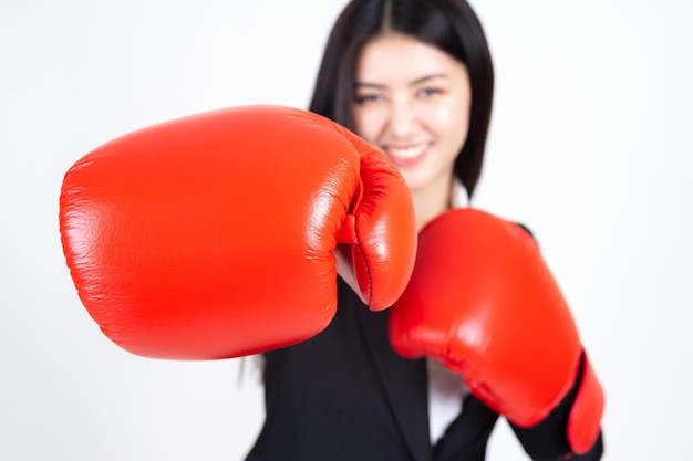 Belle jeune femme d'affaires asiatique portant un gant de boxe à la main et un costume d'affaires Gagner le concept de femme d'affaires de succès