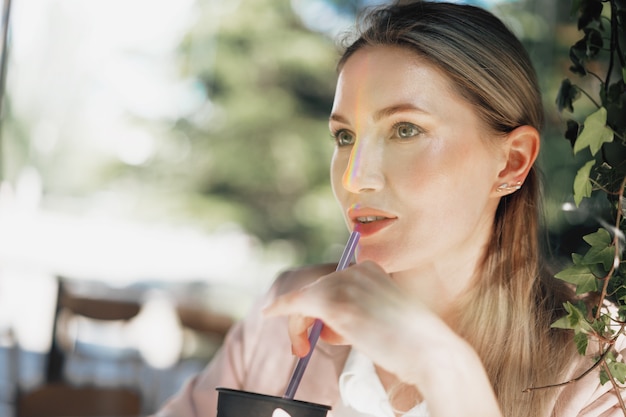 Belle jeune femme d'affaires buvant du café dans un café en plein air