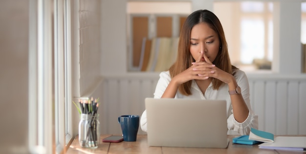 Belle jeune femme d'affaires concentrée dans son travail lors de l'utilisation de tablette numérique