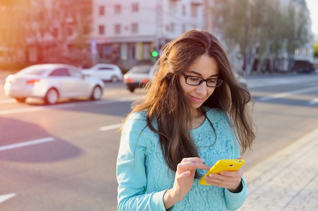 Belle jeune femme d'affaires écrit sur un smartphone