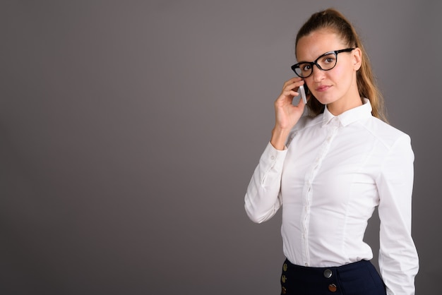 Belle jeune femme d'affaires sur fond gris