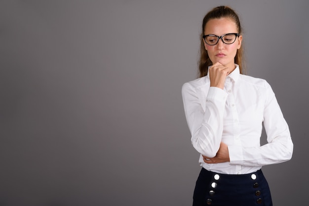 Belle jeune femme d'affaires sur fond gris