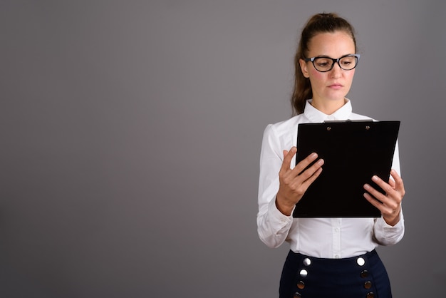 Belle jeune femme d'affaires sur fond gris