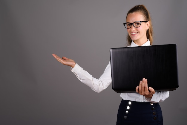 Belle jeune femme d'affaires sur fond gris