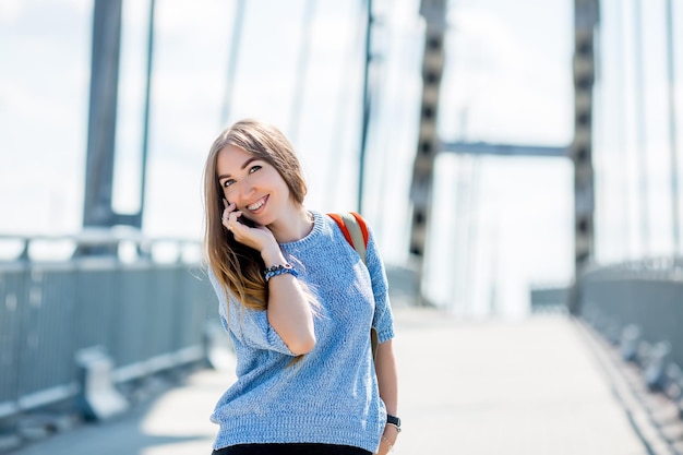 Belle jeune femme d'affaires heureuse utilisant un téléphone portable dans la rue de la ville