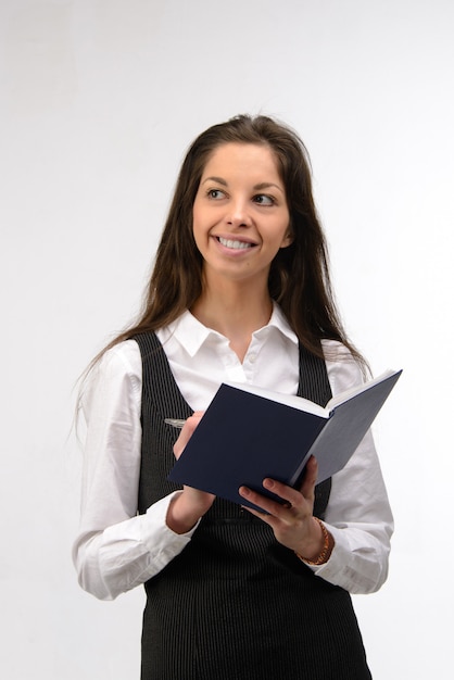 Belle jeune femme d'affaires avec ordinateur portable, sur mur blanc