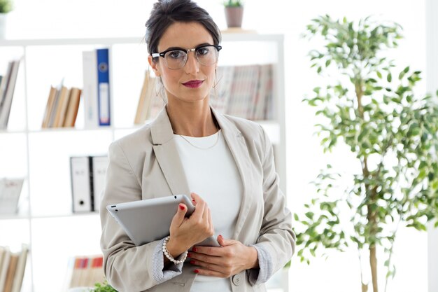 Belle jeune femme d&#39;affaires qui regarde la caméra au bureau.