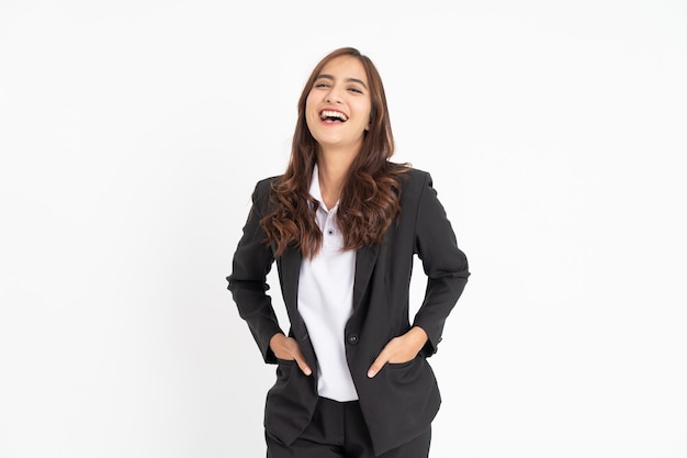 Belle jeune femme d'affaires riant joyeusement avec les deux mains dans les poches