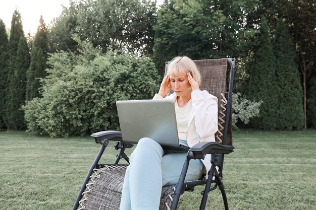 Belle jeune femme d'affaires travaillant sur un ordinateur portable pigiste travaille dans la nature