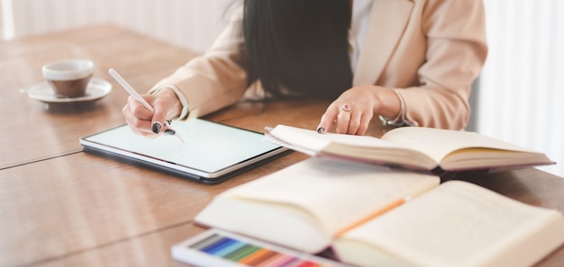 Belle jeune femme d'affaires travaillant sur son projet avec tablette numérique dans un bureau confortable