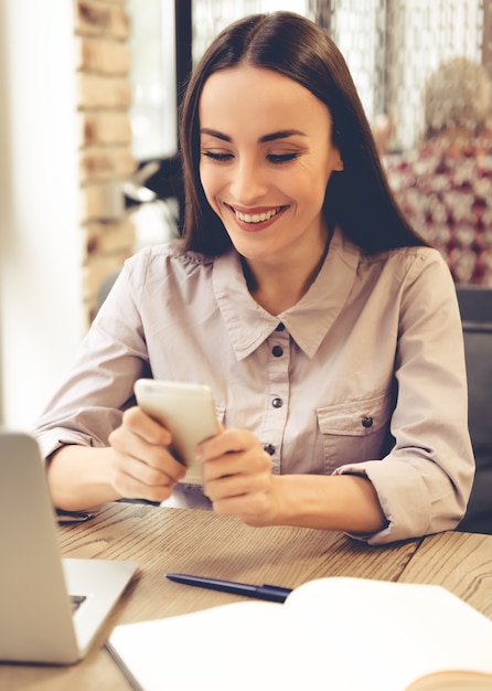 Belle jeune femme d'affaires utilise un smartphone