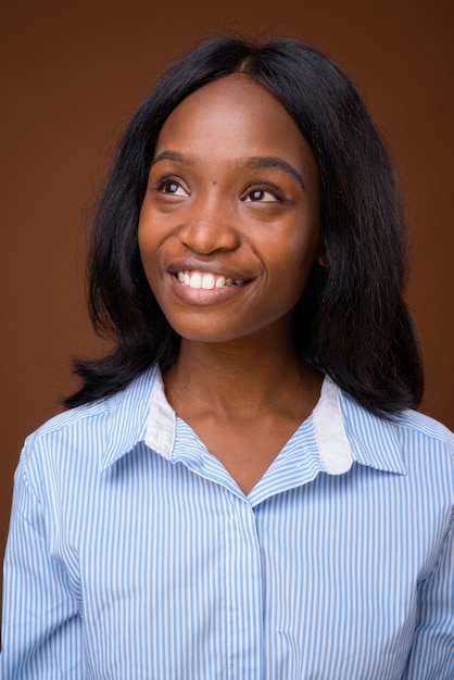 Belle jeune femme d'affaires zoulou africaine sur fond marron