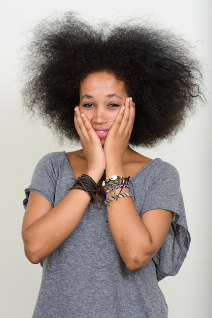 Belle jeune femme africaine aux cheveux afro sur blanc