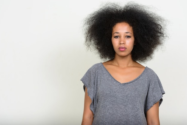 Belle jeune femme africaine aux cheveux afro sur blanc