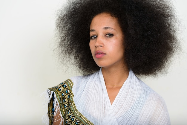 Photo belle jeune femme africaine aux cheveux afro en vêtements traditionnels sur blanc