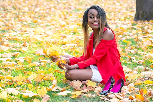 Belle jeune femme africaine feuilles d'automne