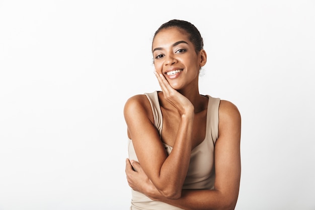 Belle jeune femme africaine habillée avec désinvolture debout isolé sur blanc, posant