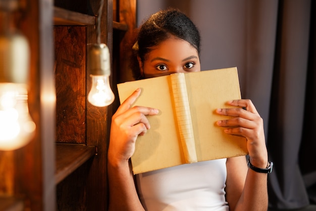 belle jeune femme africaine lisant un livre