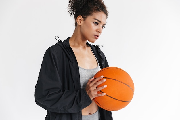 belle jeune femme africaine de remise en forme sportive incroyable posant avec le basket-ball.