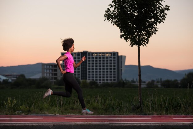 belle jeune femme afro-américaine aime courir à l'extérieur belle soirée d'été dans la ville