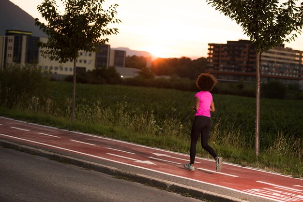 belle jeune femme afro-américaine aime courir à l'extérieur belle soirée d'été dans la ville