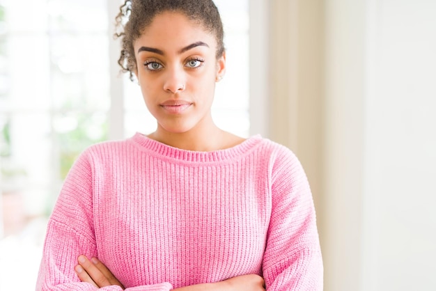 Photo belle jeune femme afro-américaine aux cheveux afro détendu avec une expression sérieuse sur le visage simple et naturel avec les bras croisés