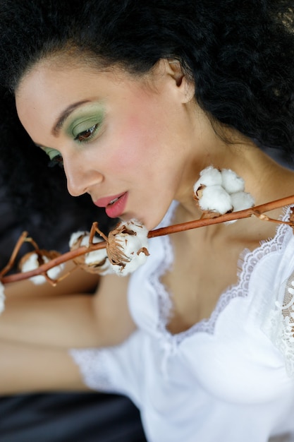 Belle jeune femme afro-américaine avec branche de coton