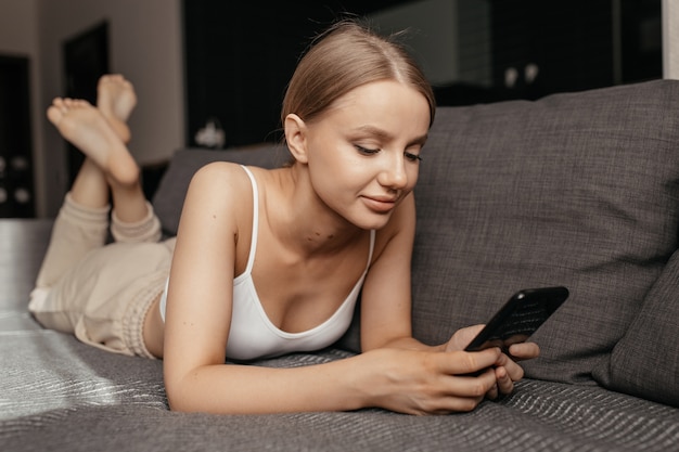 Belle jeune femme à l'aide d'un appareil électronique