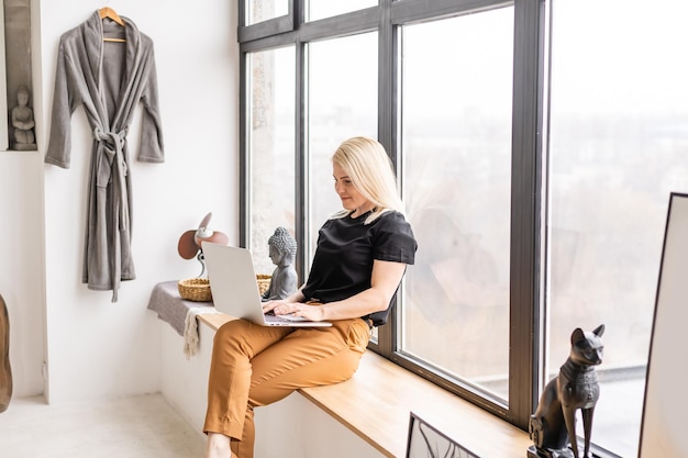 belle jeune femme à l'aide d'un ordinateur portable à la maison.